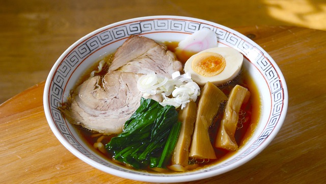 Bowl of soy sauce-based ramen topped with pork, egg, and vegetables