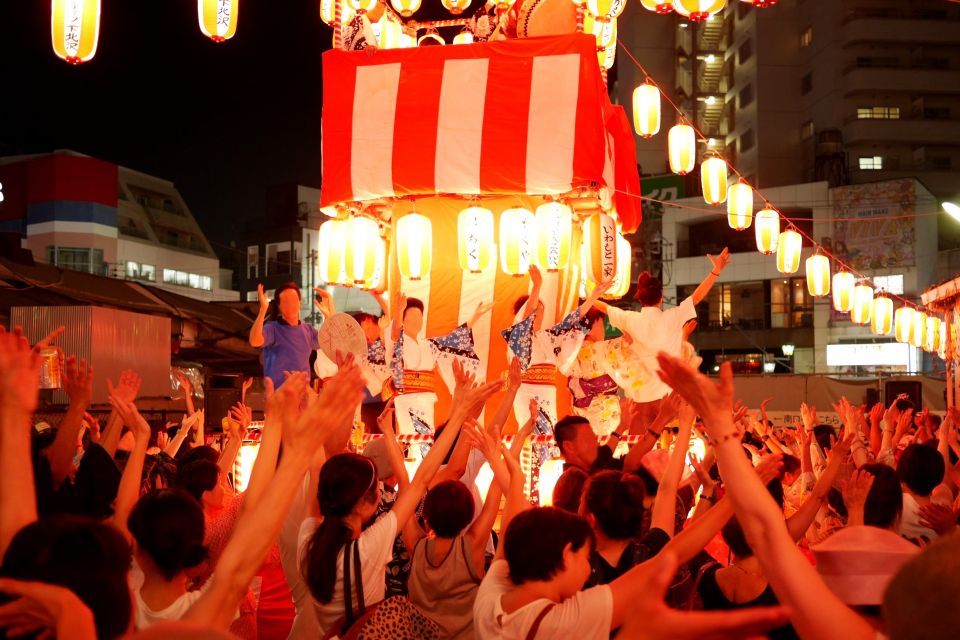 People wearing yukata dancing Bon Odori around a yagura tower