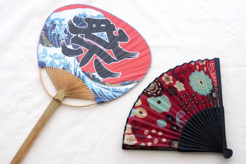 A traditional Japanese uchiwa and sensu placed side by side on a wooden surface