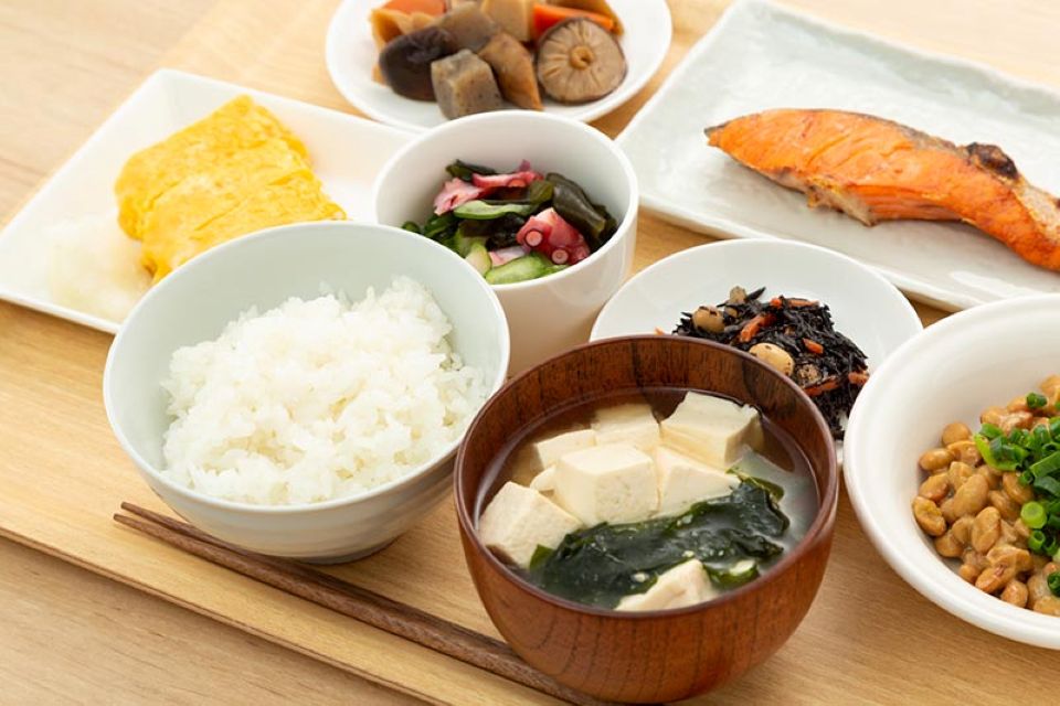 Traditional Japanese teishoku meal with grilled fish, rice, miso soup, and pickles served on a tray